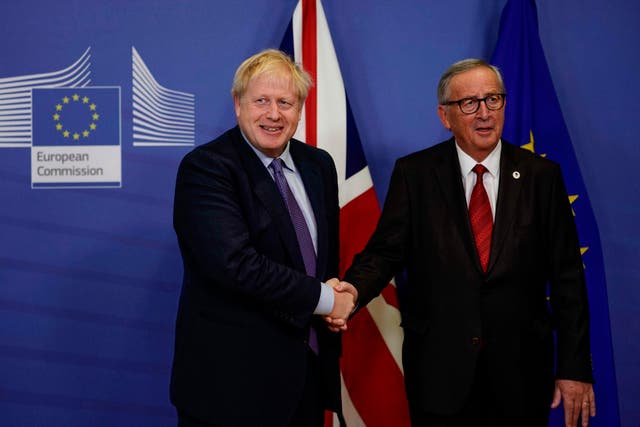 Boris Johnson shakes hands with Jean-Claude Juncker as they address a press conference in the European Commission headquarters