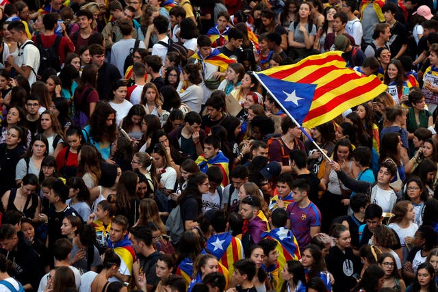 Students wave a Catalan pro-independence flag as they protest during a demonstration in front of the police headquarters in Barcelona