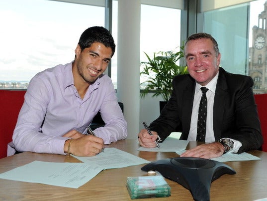 Luis Suarez signs a new Liverpool contract with Managing Director Ian Ayre in 2012