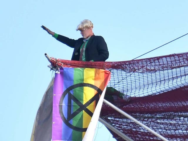 An Extinction Rebellion protester who scaled the scaffolding surrounding Big Ben unfurls a banner