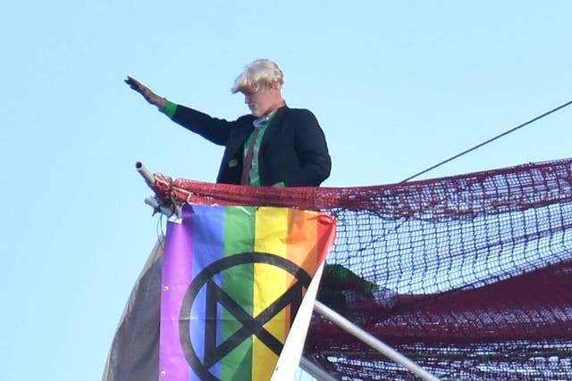 An Extinction Rebellion protester who scaled the scaffolding surrounding Big Ben unfurls a banner