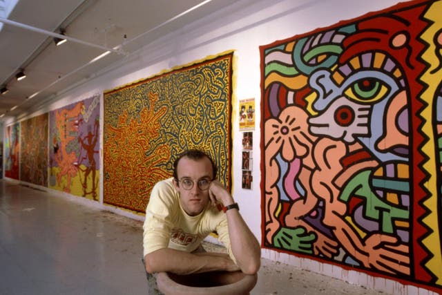 Keith Haring standing in front of his paintings circa 1985.