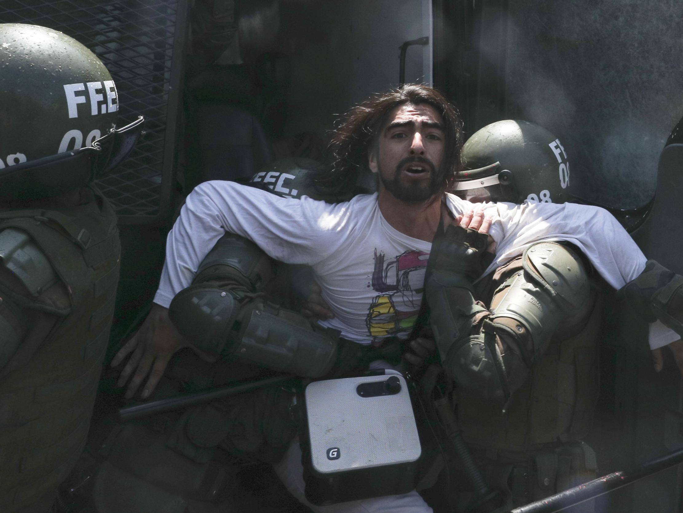 Police detain a protester in Santiago