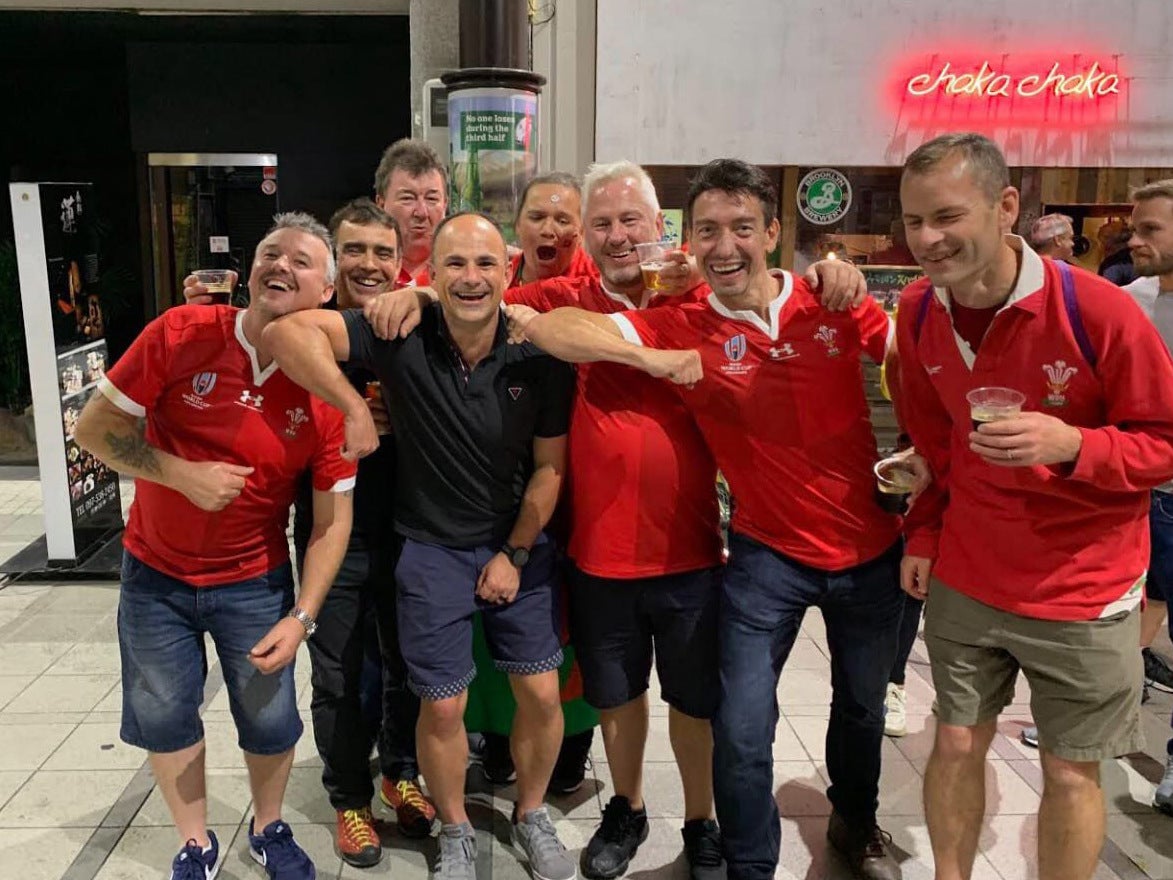 Peyper (in black) poses with Wales fans appearing to gesture an elbow to one of them