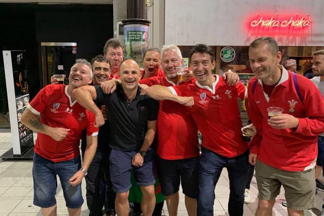 Peyper (in black) poses with Wales fans appearing to gesture an elbow