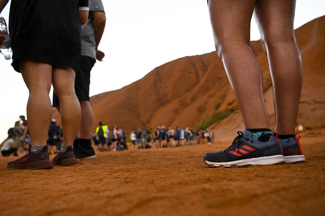 Tourists line up to climb Uluru