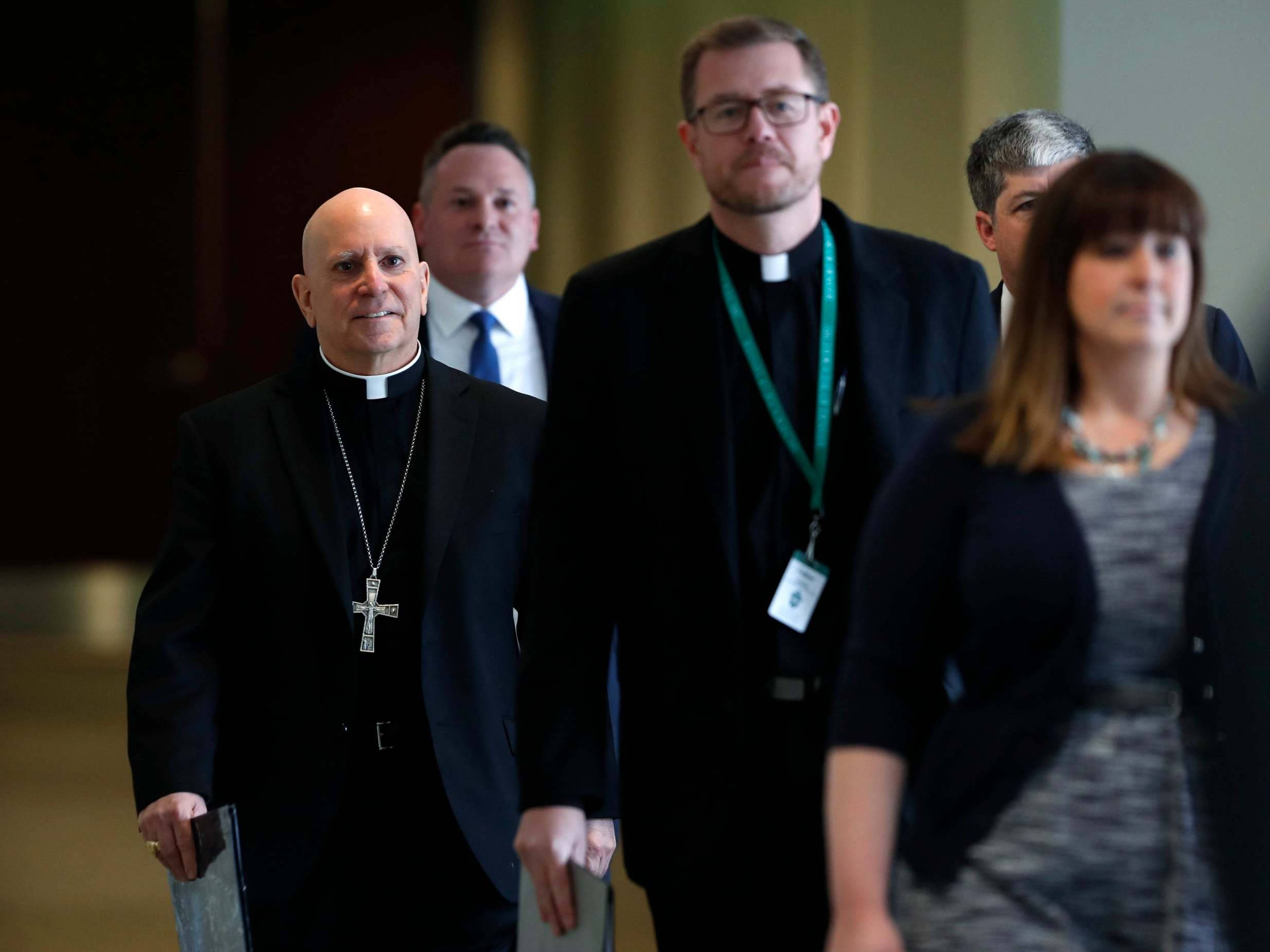 Samuel Aquila, archbishop of the Denver diocese of the Roman Catholic Church, left, trails Very Rev. Randy Dollins, vicar general, into a news conference at which a plan was revealed to have a former prosecutor review their diocese's sexual abuse files