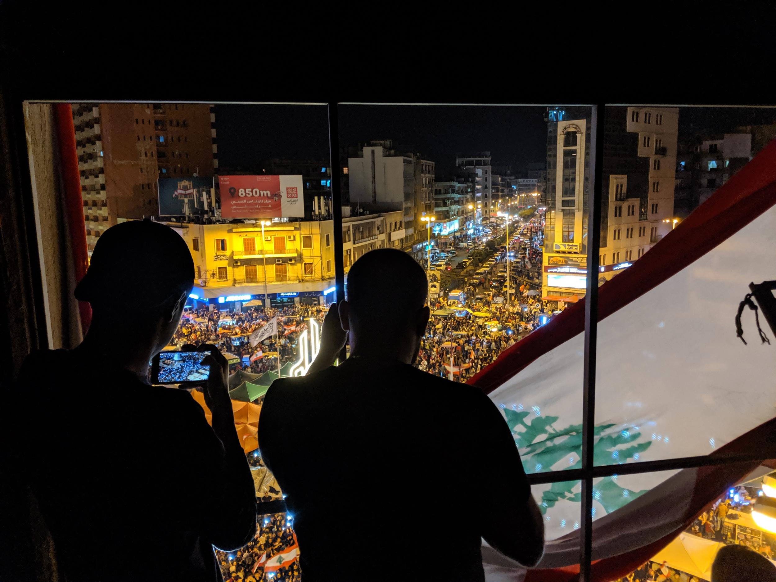 Sixteen-year-old Kareem Shlaylat, a IT student, takes a picture of the crowds in Nour Square (Richard Hall/The Independent)