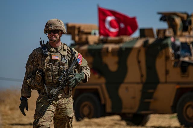 A US soldier stands guard during a joint patrol with Turkish troops in the Syrian village of al-Hashisha on the outskirts of Tal Abyad