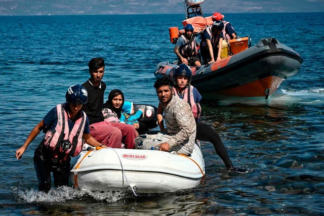 Migrants helped by rescuers arrive on the Greek island of Lesbos after crossing the Aegean Sea from Turkey