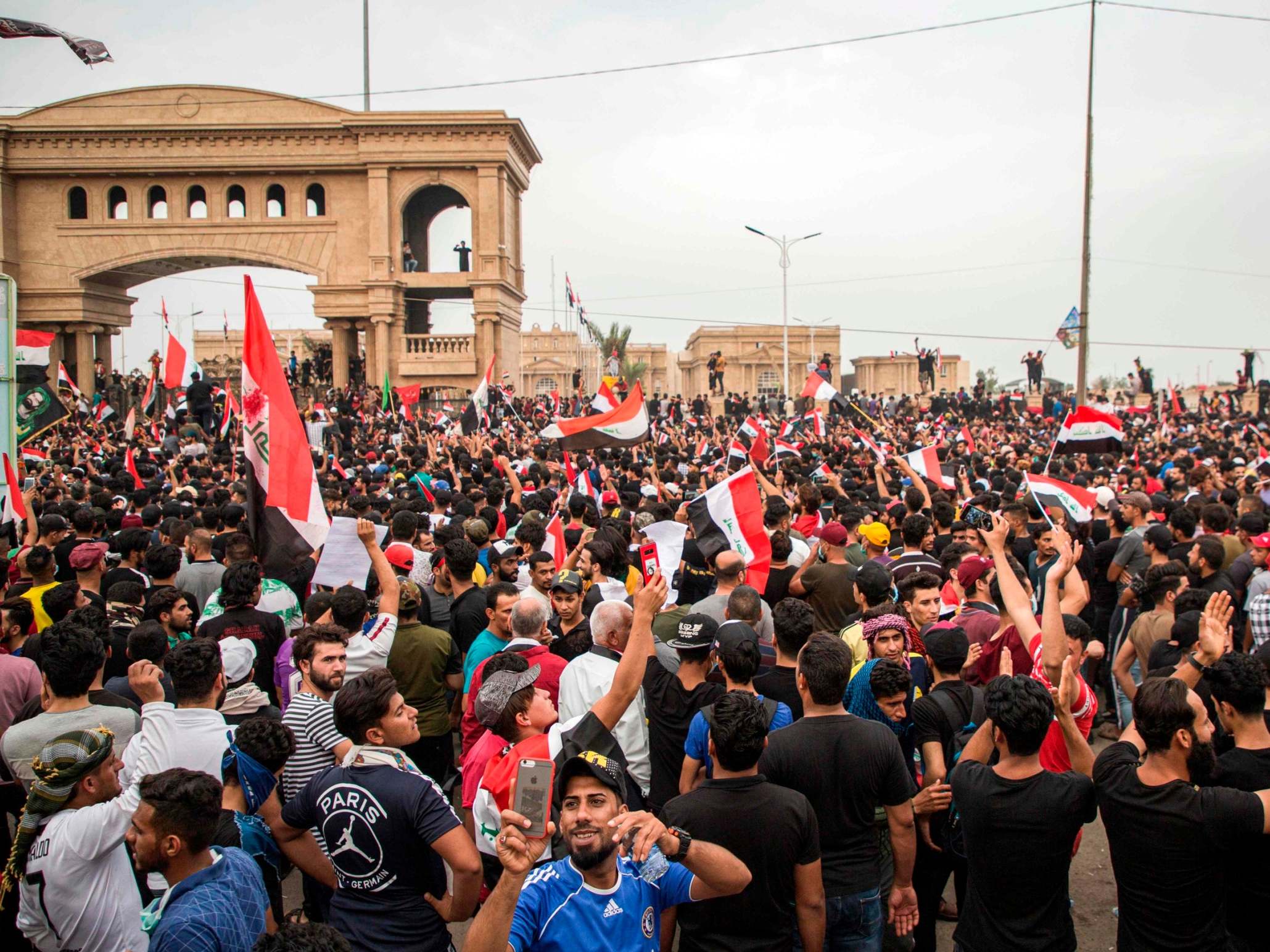 Iraqi protesters gather during an anti-government demonstration outside the local government headquarters in the southern city of Basra