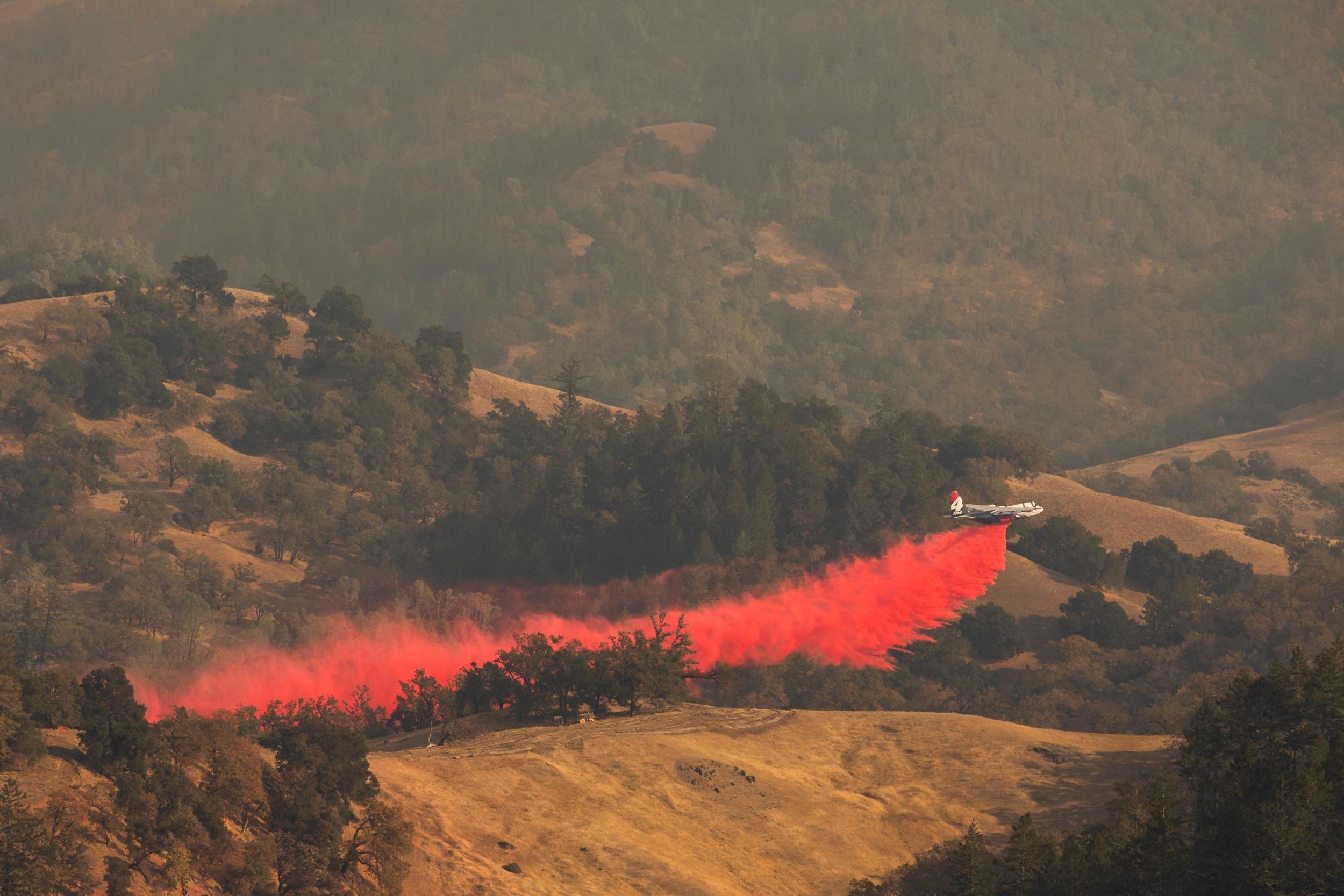 An air tanker drops fire retardant in the valley below?in Healdsburg, California, on 26 October?2019