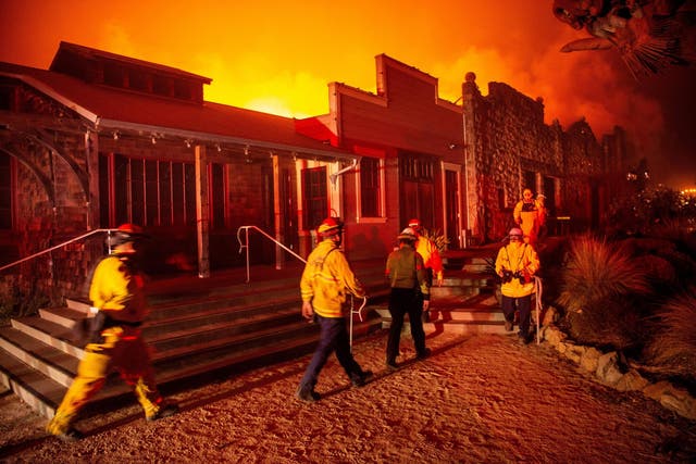 Firefighters survey the Soda Rock Winery as it burns during the Kincade fire as flames race through Healdsburg, California, on 27 October 2019