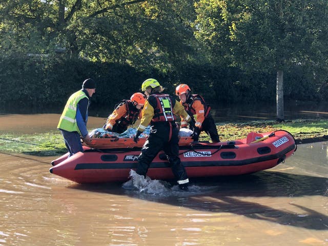 A resident is evacuated by boat after flooding in Hereford