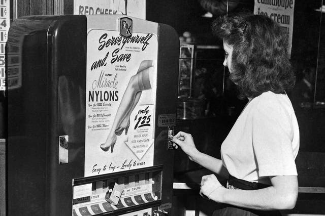 A young woman buys nylon stockings from an automatic vending machine in a New York restaurant in 1946