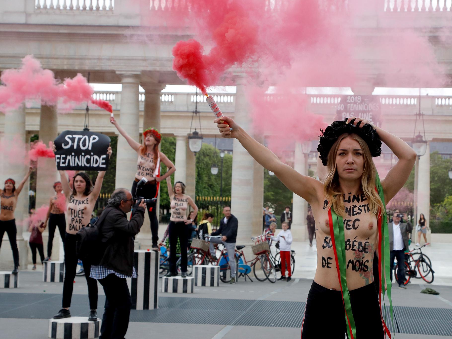 Femen leader Inna Shevchenko brandishes a flare during a protest against femicide outside the Palais Royal in Paris in May