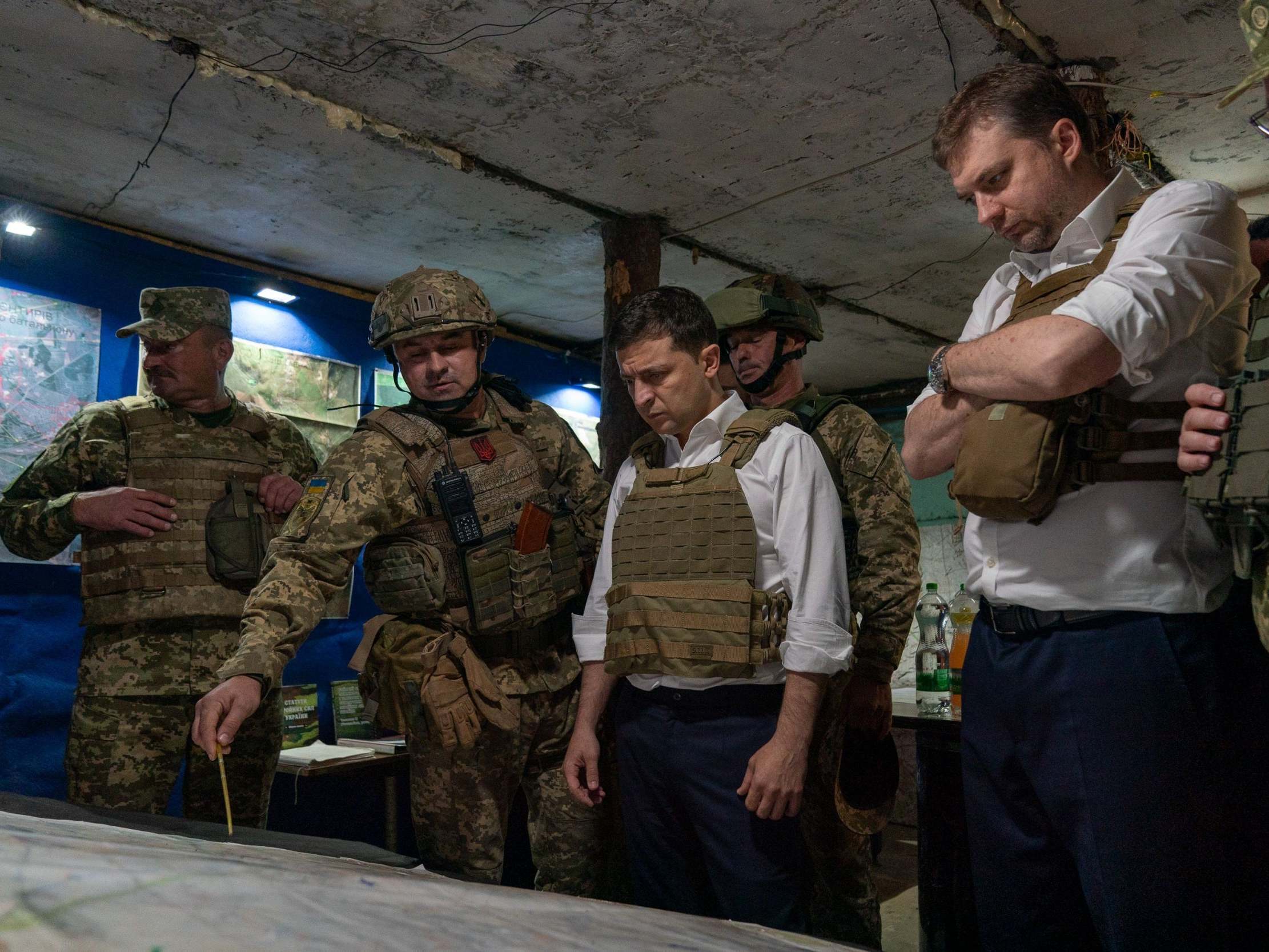 Volodymyr Zelensky (centre) talking with officers at a map during his visit to the Donetsk region