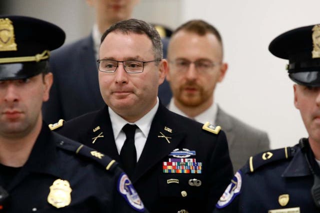 Lt Col Alexander Vindman, second left, leaves a closed-door meeting after testifying for 10 hours as part of the impeachment inquiry into Donald Trump