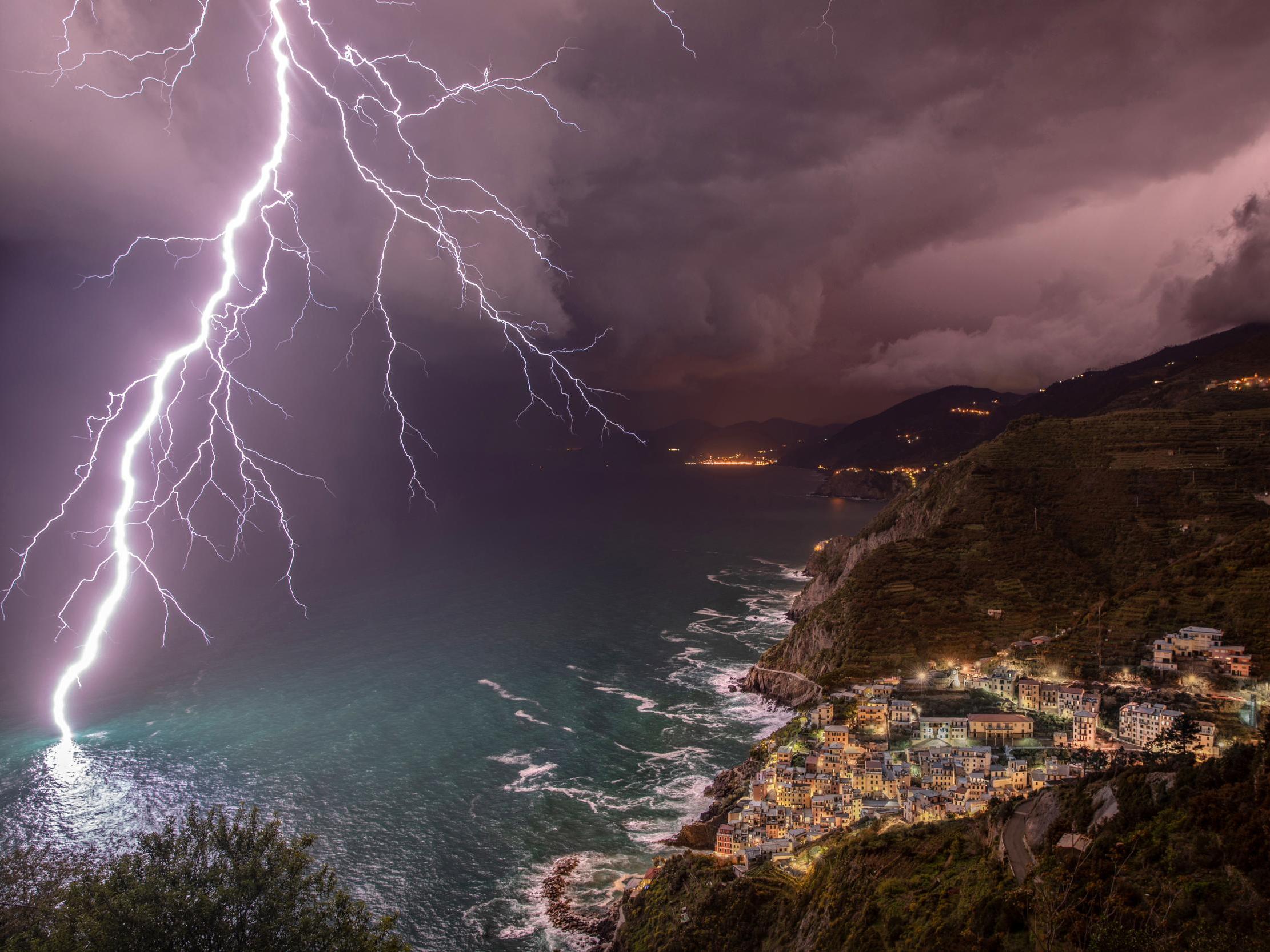 1st RUNNER-UP: A very large and impressive bolt striking the sea facing the characteristic village of Riomaggiore, in the Cinque Terre UNESCO heritage site, Liguria, Italy