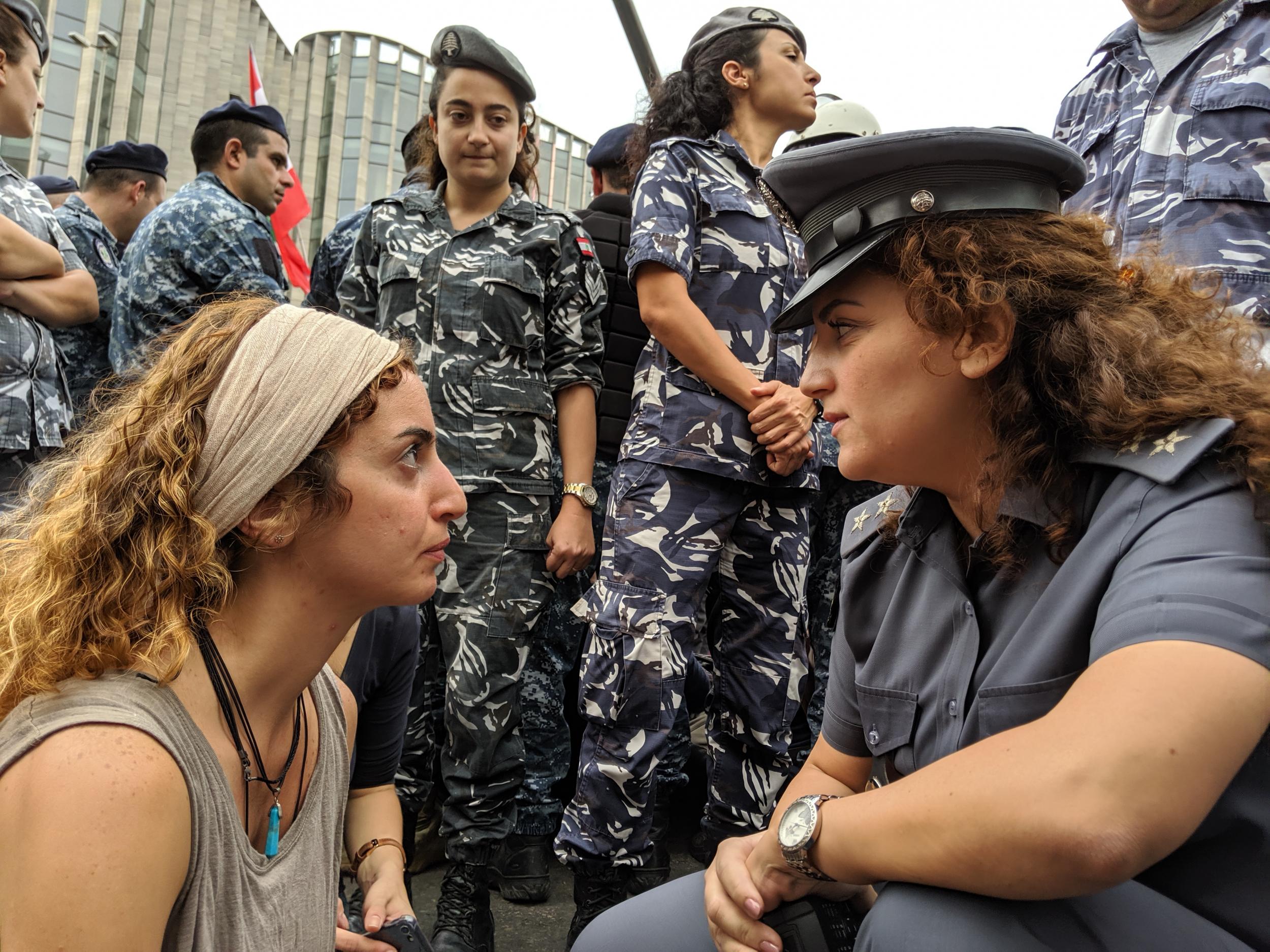 A protester faces off with a police officer at a roadblock sit-in in Beirut