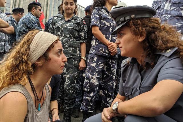 A protester faces off with a police officer at a roadblock sit-in in Beirut