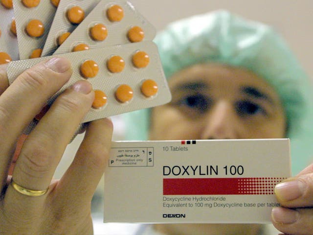 A worker at the Dexxon pharmacuticals plant holds up a package of their Doxylin antibiotics drug November 8, 2001 in the Israeli town of Or Akiva