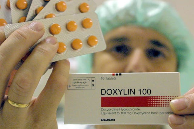 A worker at the Dexxon pharmacuticals plant holds up a package of their Doxylin antibiotics drug November 8, 2001 in the Israeli town of Or Akiva