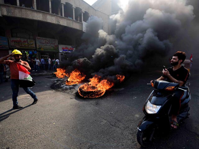 Protesters have blocked central Baghdad roads with cars, burning tyres and barbed wire