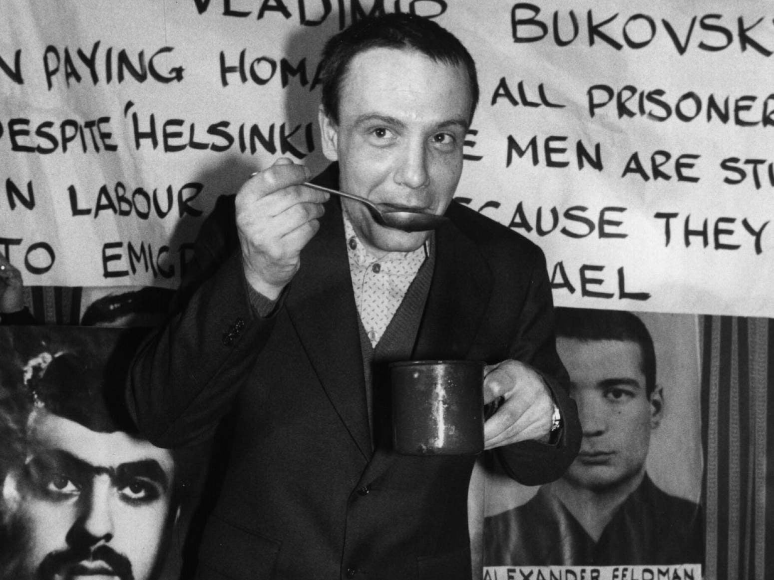 Bukovsky in 1977, soon after he was released from prison: surrounded by posters of prisoners of conscience, he tastes a symbolic meal to pay homage to those still held