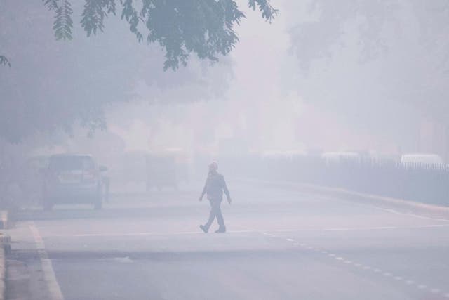 A man crosses a street in smoggy conditions in Delhi on 4 November, 2019