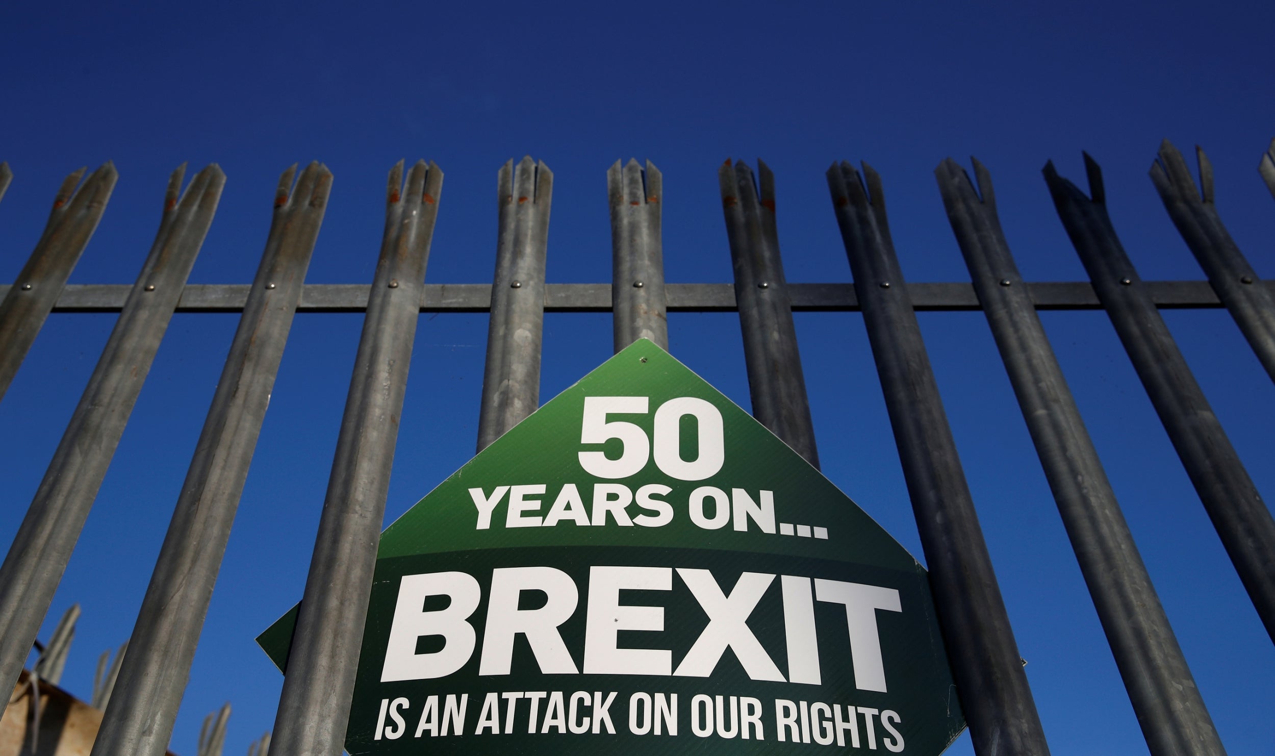 A Sinn Fein anti-Brexit sign hangs on a fence at the border between Ireland and Northern Ireland