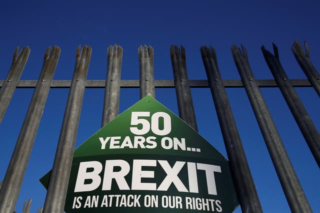 A Sinn Fein anti-Brexit sign hangs on a fence at the border between Ireland and Northern Ireland