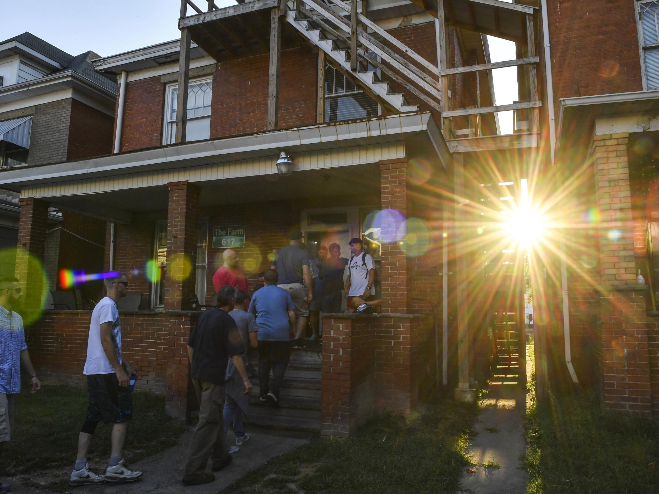 Recovering addicts who are residents of the Farm recovery centre make their way indoors for a meeting