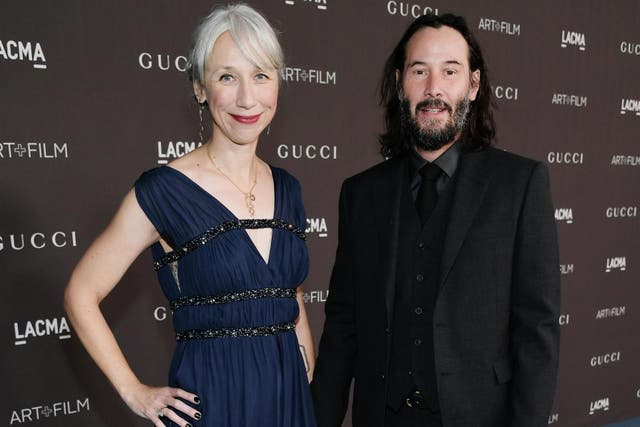 Keanu Reeves holds hands with Alexandra Grant on red carpet (Getty)
