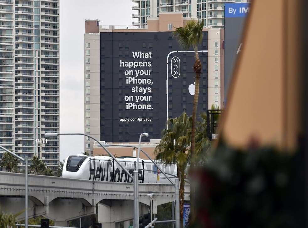 A monorail train featuring a Google ad passes by a billboard advertising Apple's iPhone security during CES 2019 on January 07, 2019 in Las Vegas, Nevada