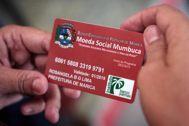 A woman uses her ‘Mumbuca’ card at pharmacy in Marica, Brazil