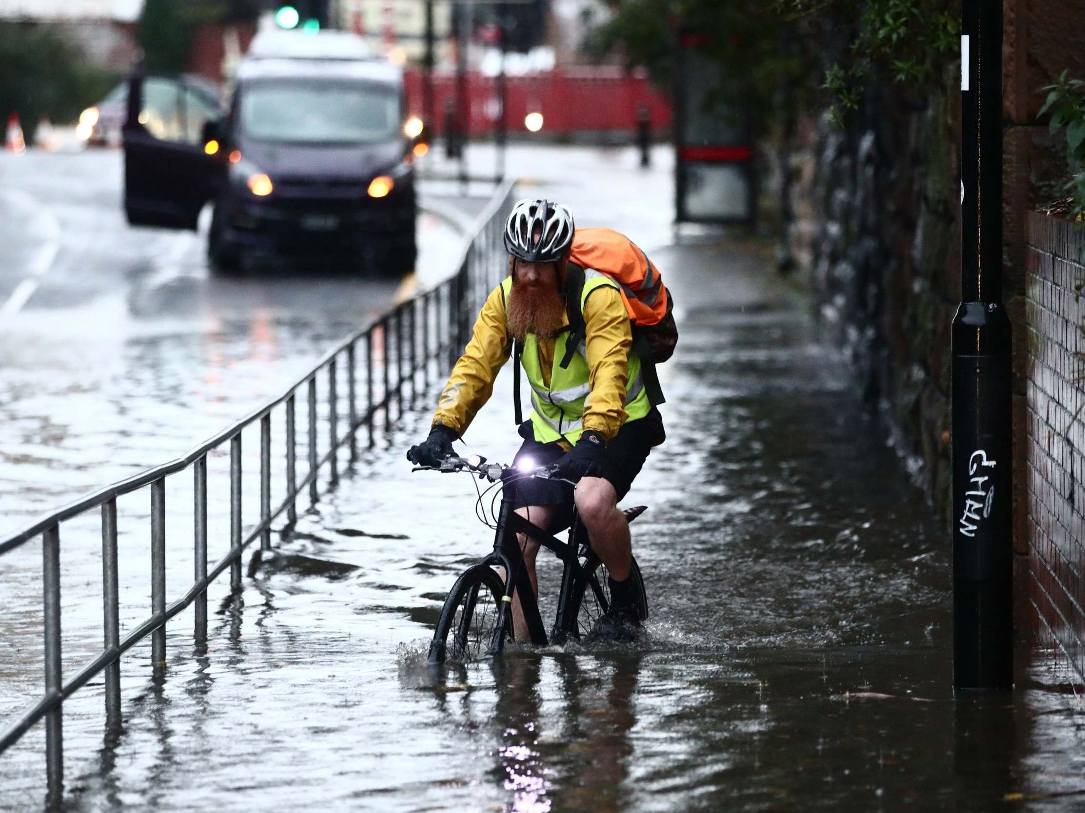 A man cycles through a flooded street in Sheffield