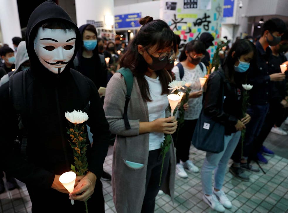People pay tribute with flowers to Chow Tsz-lok, 22, a university student who fell during protests at the weekend and died early on Friday morning, at the Hong Kong University of Science and Technology which he attended