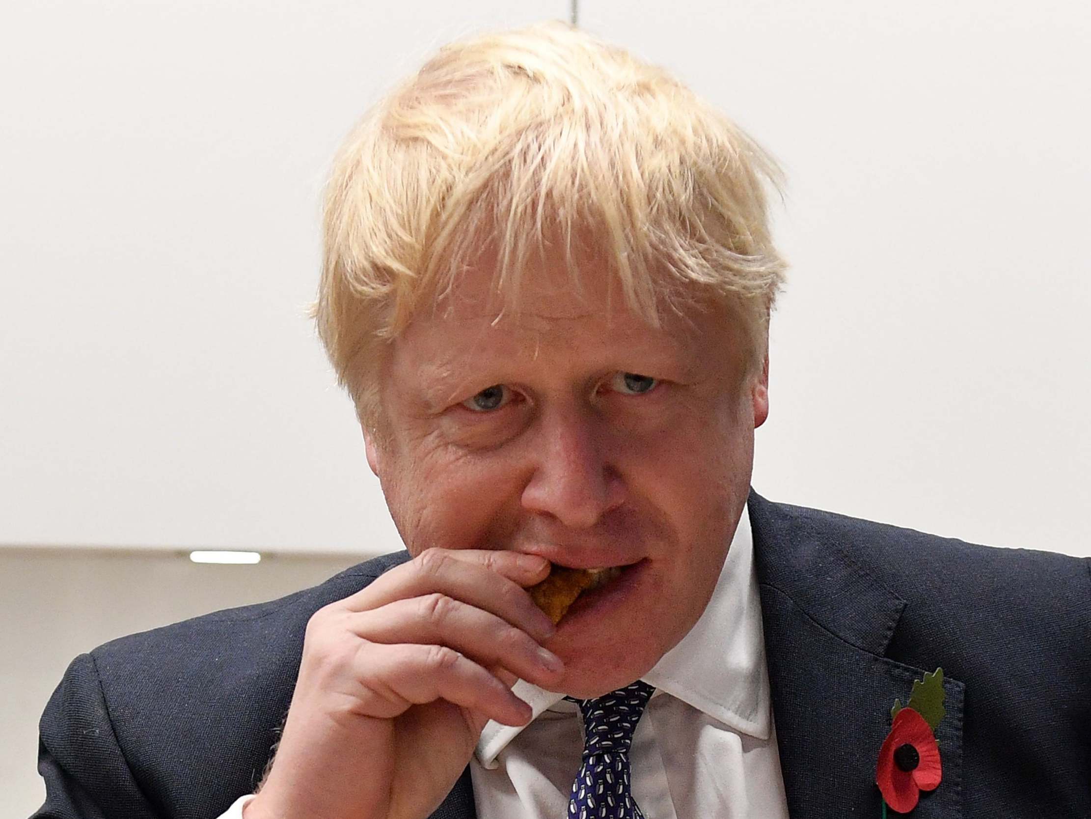 Johnson tastes a chicken product during a quality test at the Iceland headquarters in Deeside on Friday