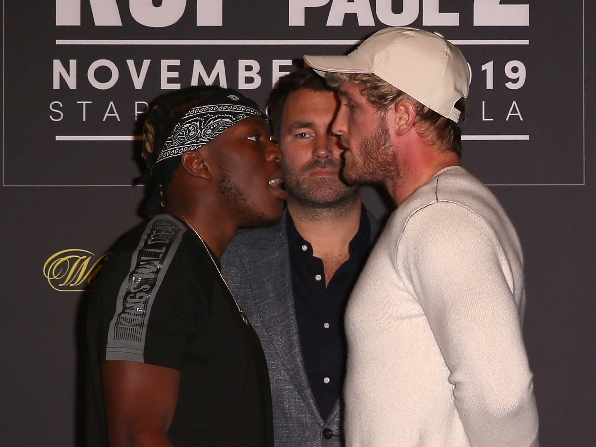 KSI and Logan Paul face off onstage while promoter Eddie Hearn looks on