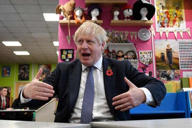 Boris Johnson gestures as he talks with teachers - but not sixh formers - during visit to George Spencer Academy in Stapleford, Nottinghamshire