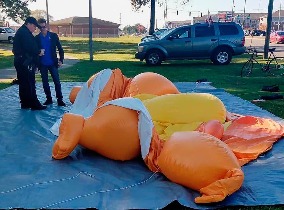 A Baby Trump balloon lies deflated at the park where anti-Trump demonstrators were protesting the president's visit