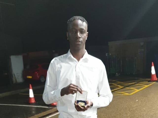 Hakim Sillah, 18, who was stabbed to death on Thursday at Hillingdon Civic Centre, holding an award he won in school for excellence in history