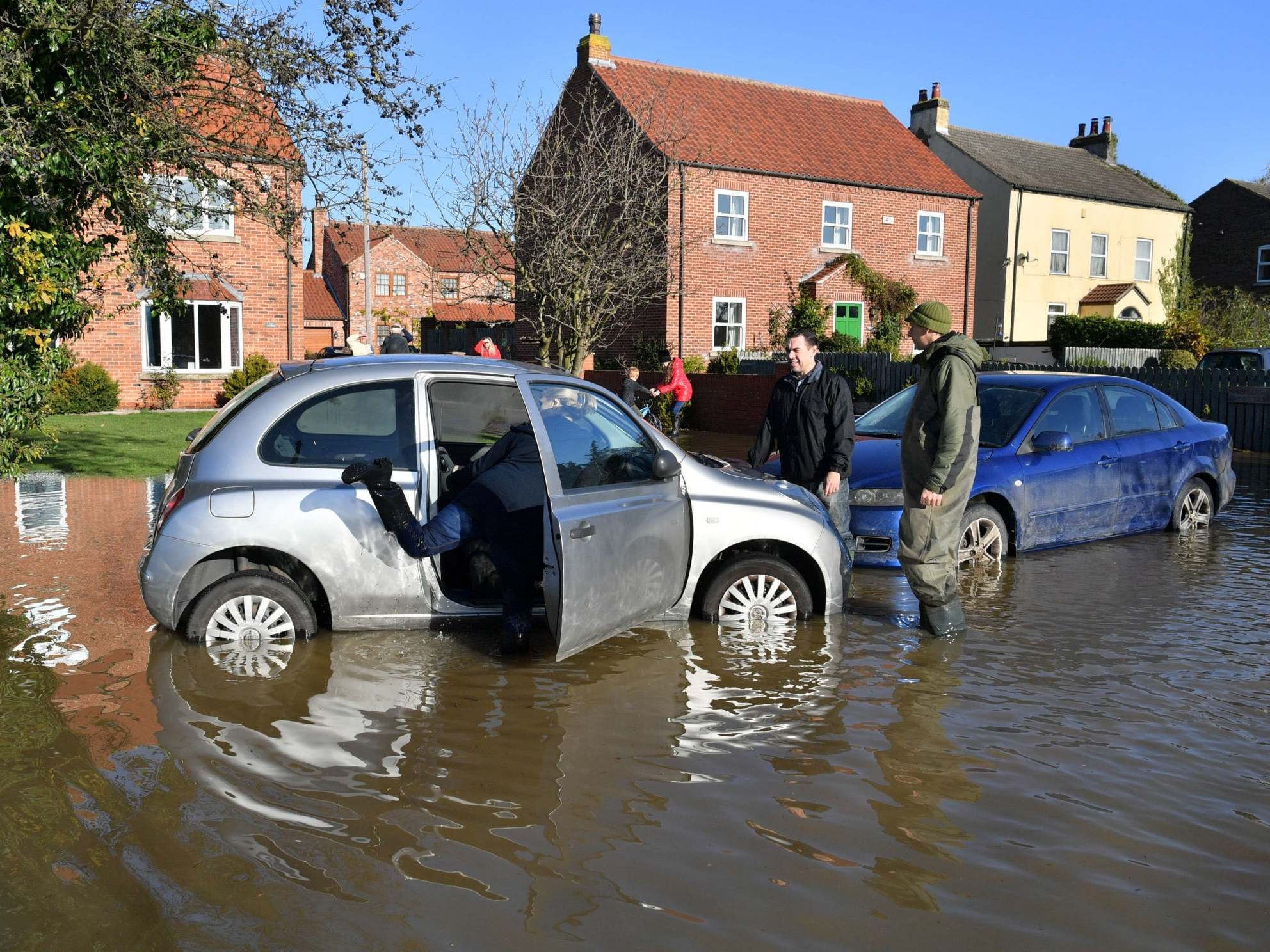 A woman prepares to remove a car from floodwater in Doncaster this week