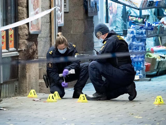 <p>Police forensics examine the crime scene where a 15-year-old was fatally hit and another severely wounded when attackers opened fire on a pizzeria before fleeing the scene on bicycles in Malmo, Sweden</p>