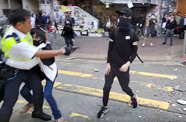 A video grab shows the moment a police officer shoots a black-clad pro-democracy protester in the abdomen during a protest in Sai Wan Ho district, in Hong Kong, on Monday morning