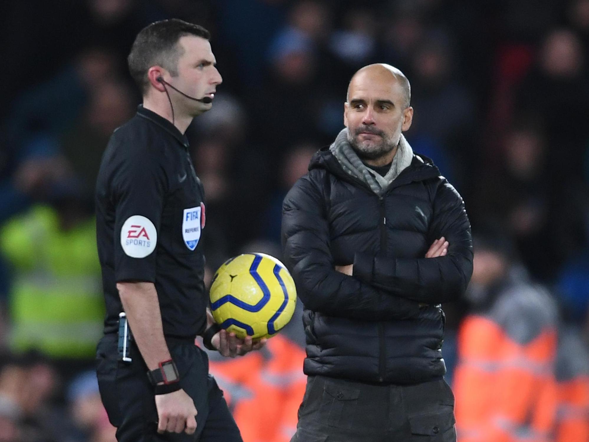 Referee Michael Oliver and Manchester City manager Pep Guardiola