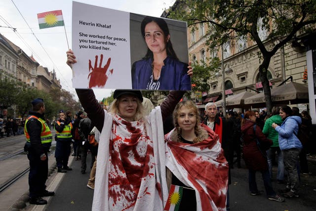 A demonstrator holds up a poster with a portrait of Kurdish politician Hevrin Khalaf who was summarily executed by members of the Syrian National Army