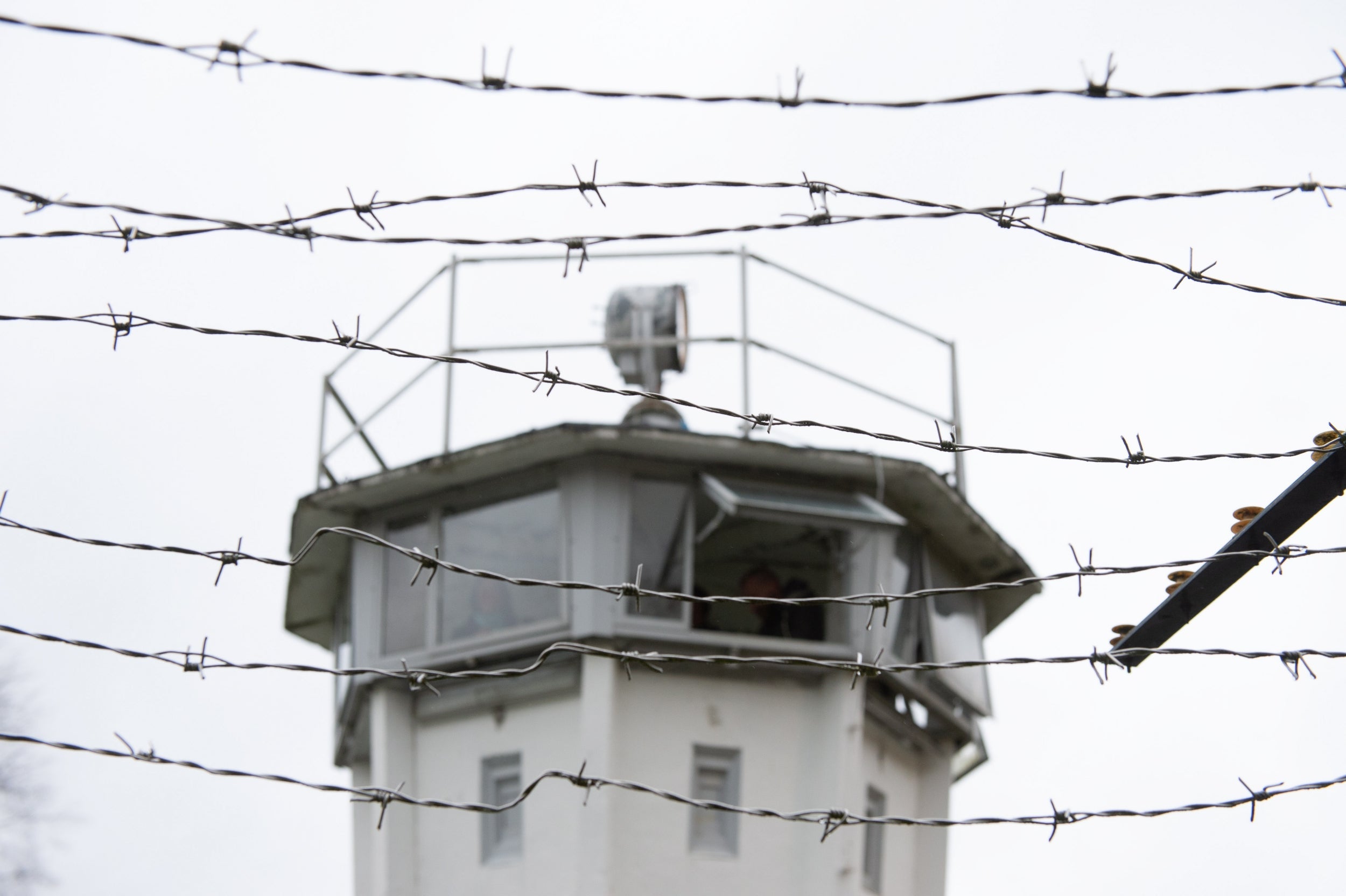 A watchtower behind a barbed fence on the former border between East and West Germany