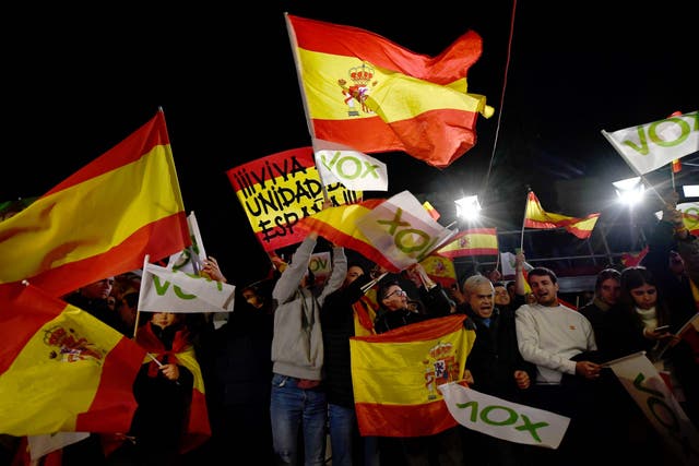 Spanish far-right Vox supporters wave flags as they celebrate outside the party’s headquarters in Madrid on Sunday night